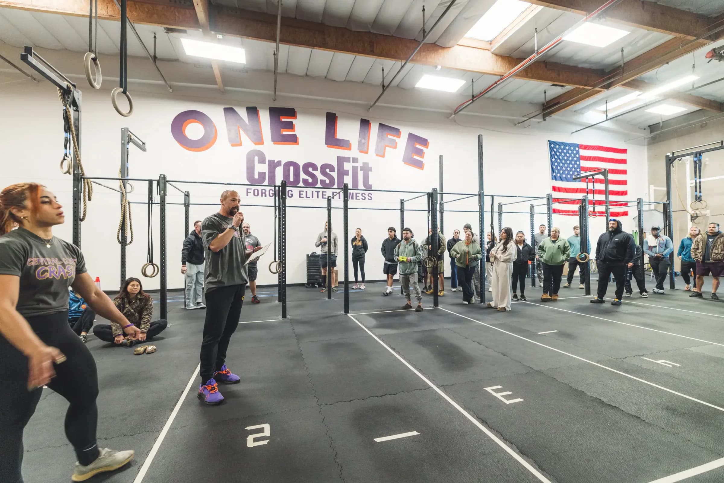 A One Life coach briefing members on the Santa Maria training floor