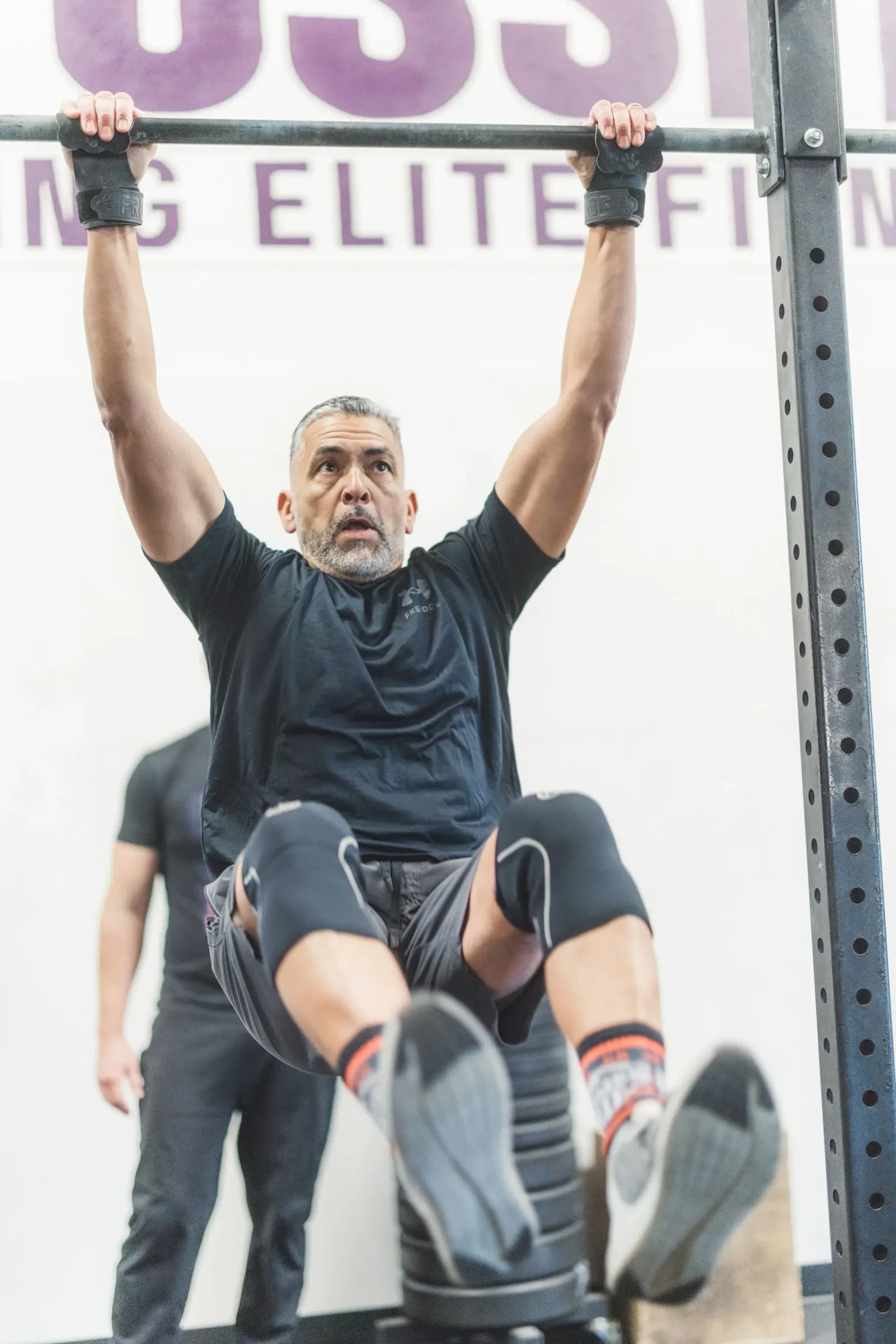 One Life member practicing ring strength with a coach nearby