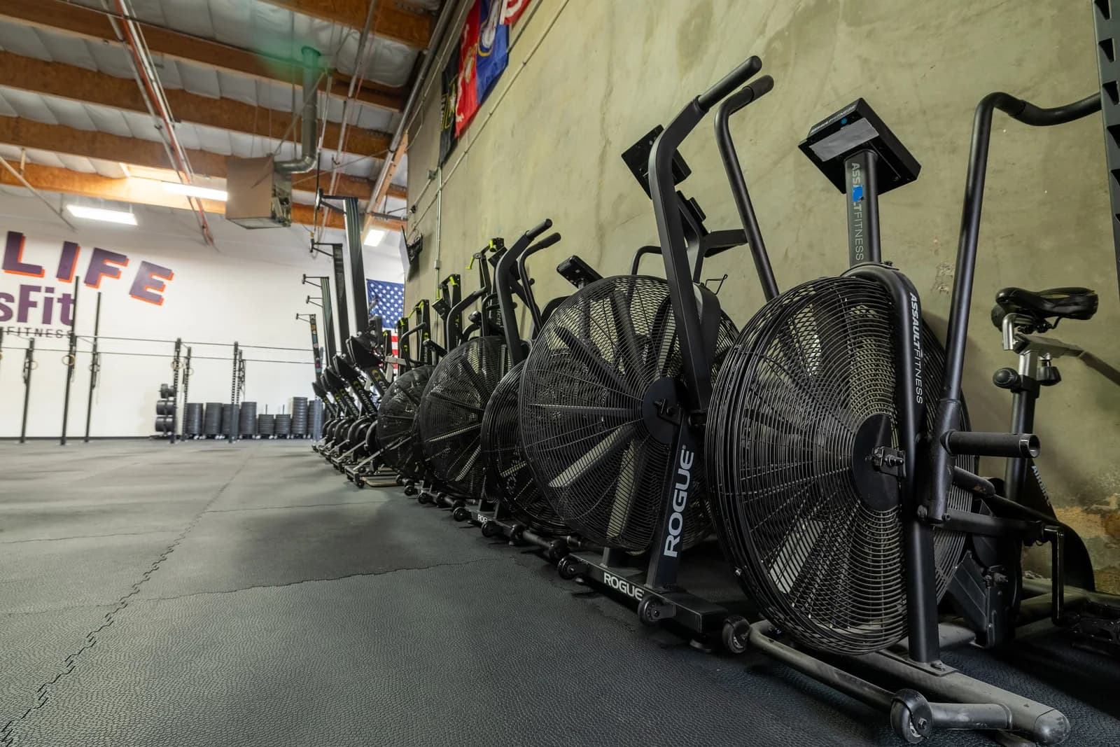 Air bikes arranged beside the open One Life CrossFit training floor