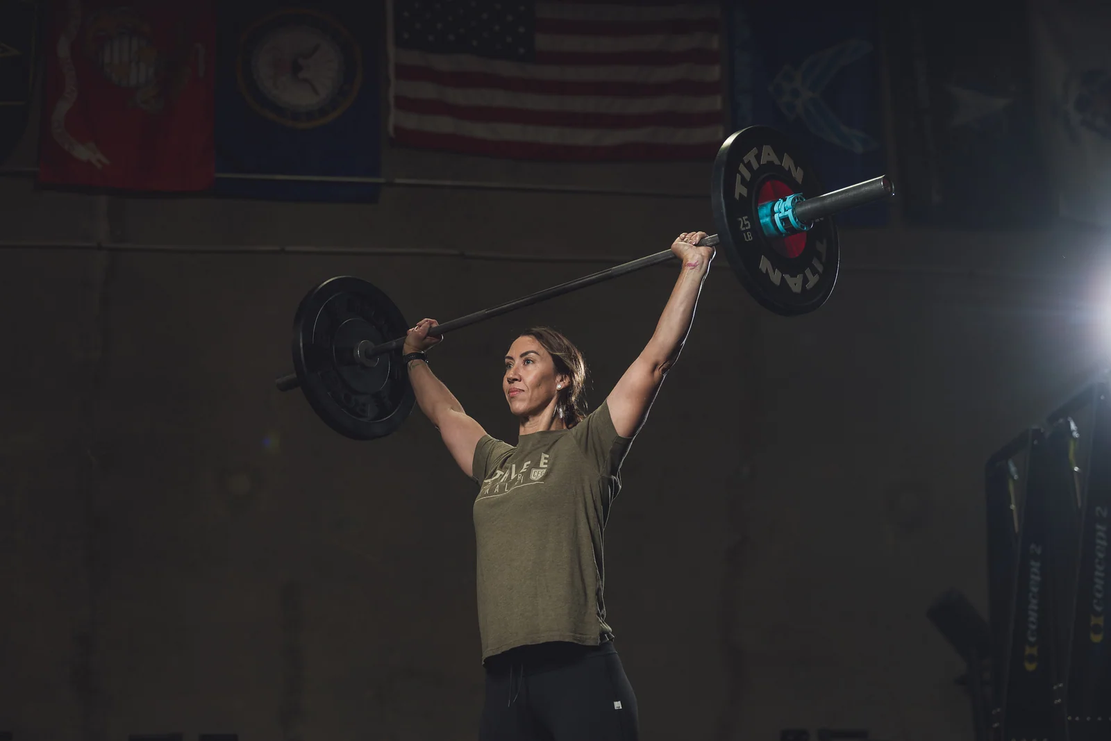 One Life CrossFit member lifting a barbell overhead on the Santa Maria gym floor