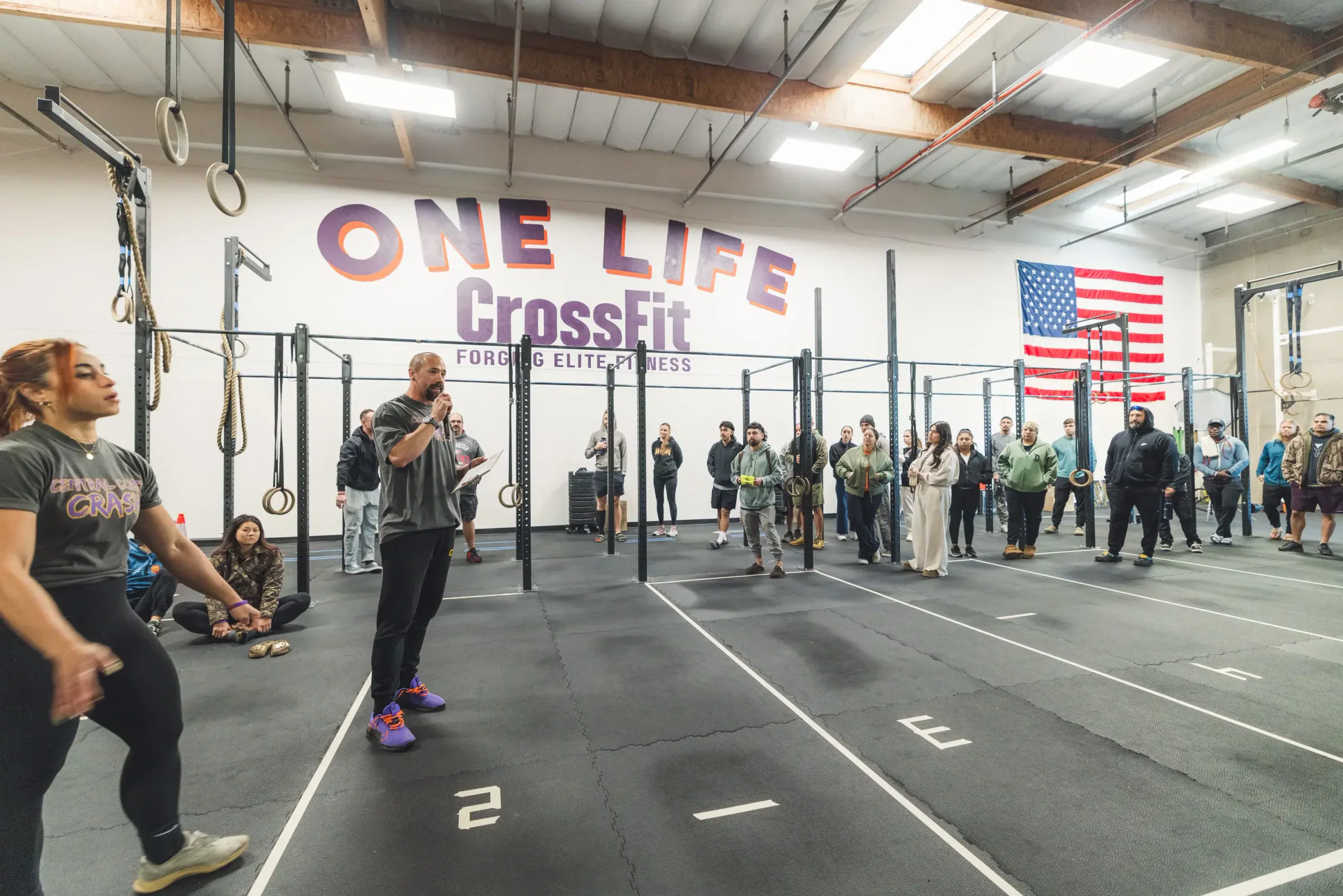 A One Life coach briefing members on the Santa Maria training floor