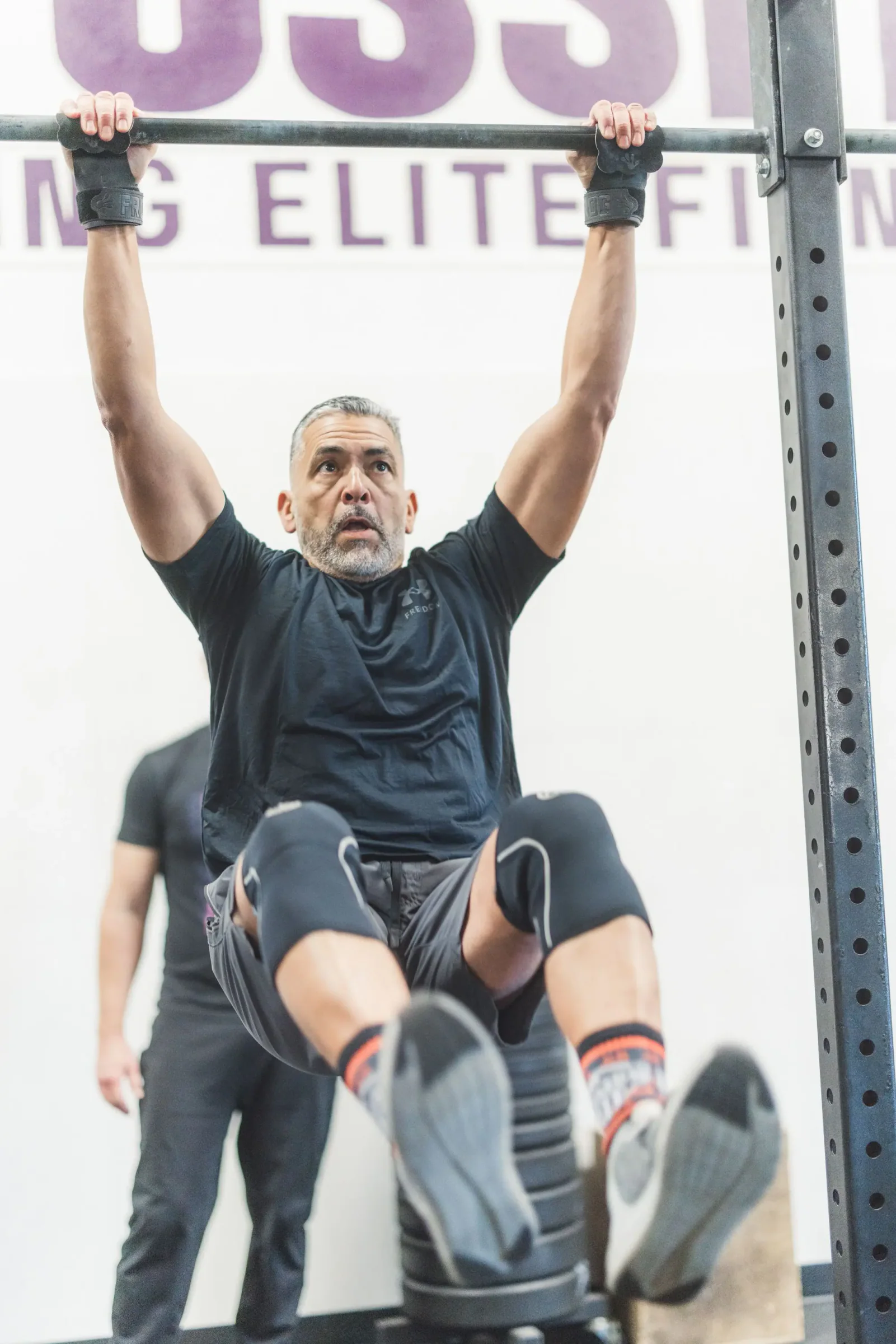 One Life member practicing ring strength with a coach nearby